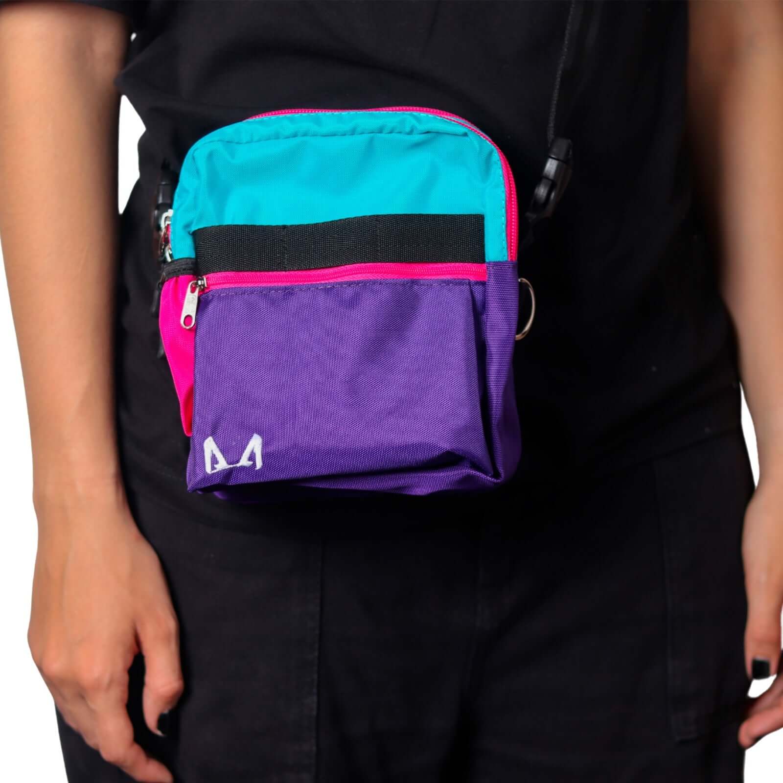 Multicolored purple, pink and blue dog training crossbody bag on a person wearing black clothing.