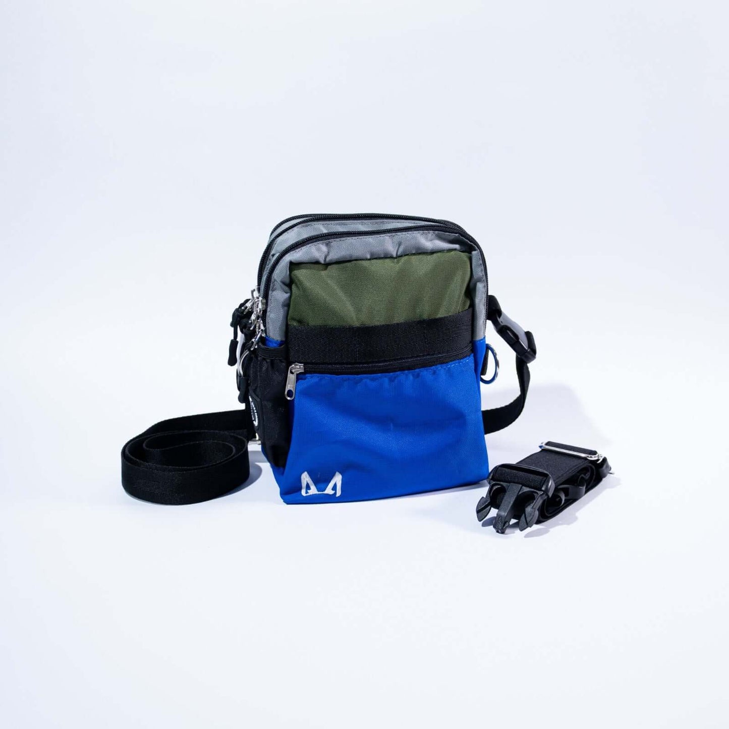 Royal blue and green crossbody bag with a strap on a white background