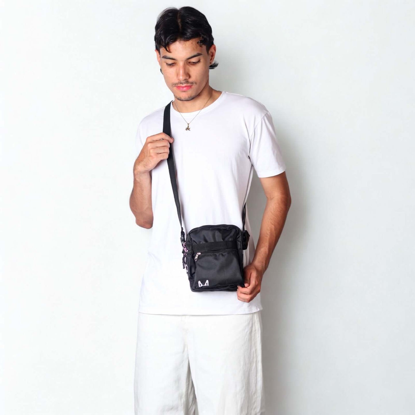 Person wearing a black crossbody dog training bag against a white background