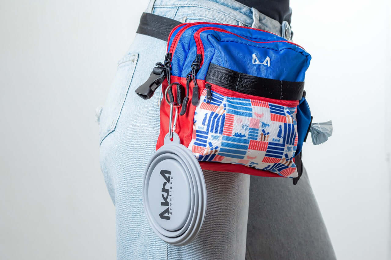 Person wearing a colorful waist bag with a visible brand logo on a plain background