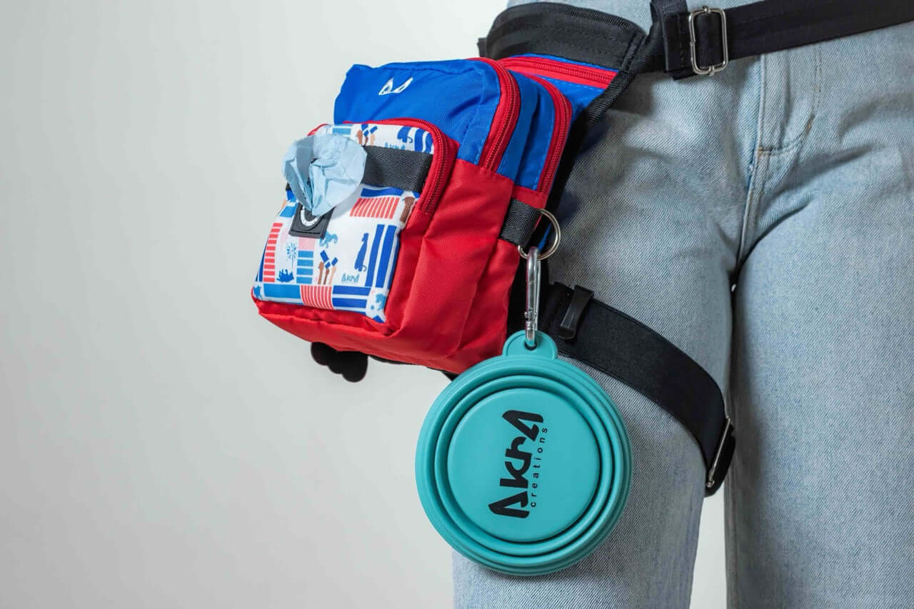 Person wearing a red and blue bag with a teal Akra container attached, on a plain background