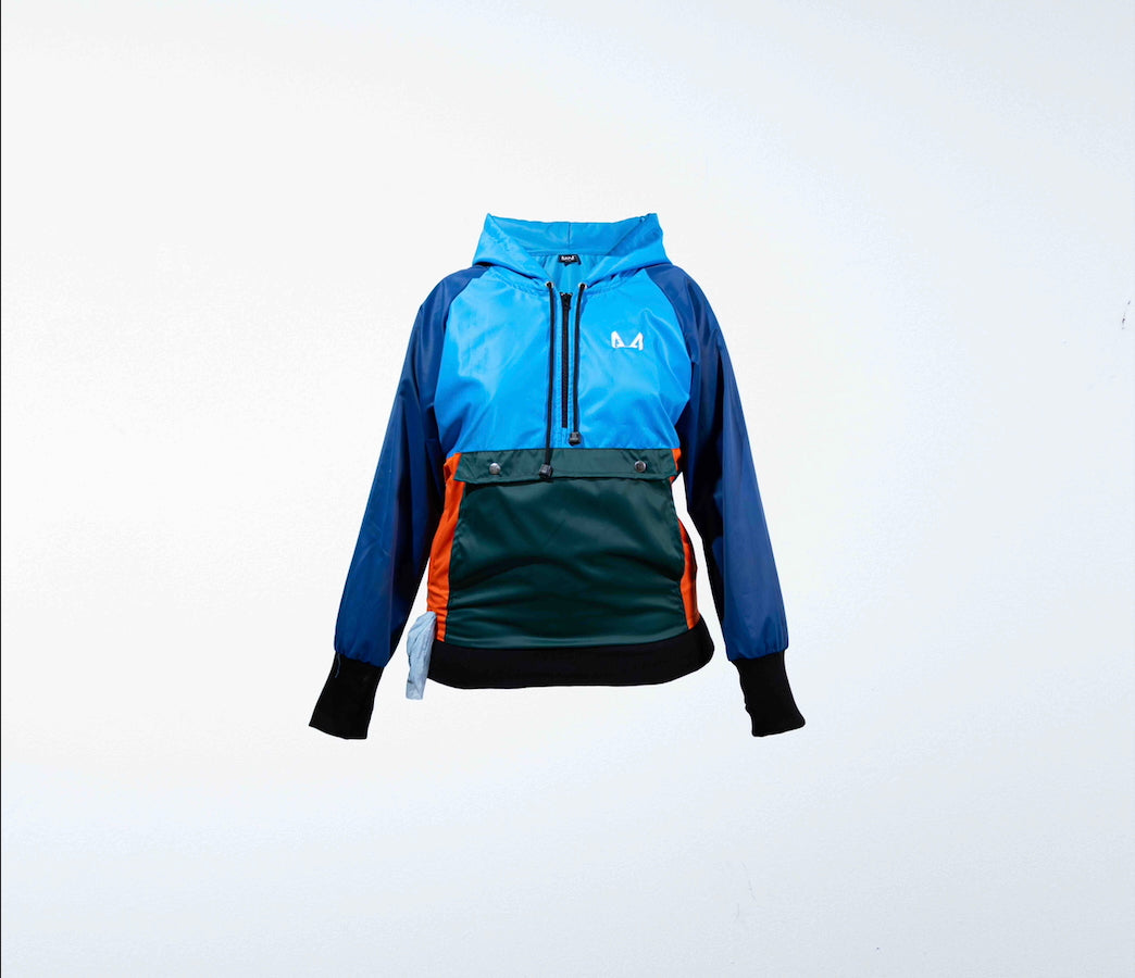Multicolored dog training windbreaker with blue, green, and orange sections on a white background