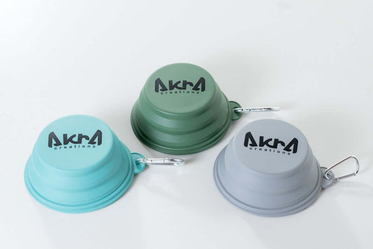 Three collapsible bowls in green, blue, and gray with 'AKRA Creations' branding on a white background.
