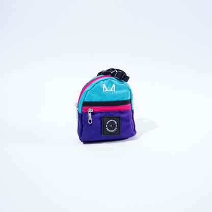 Small multicolored purple, pink and light blue poop bag and treat holder with a visible brand logo on a white background