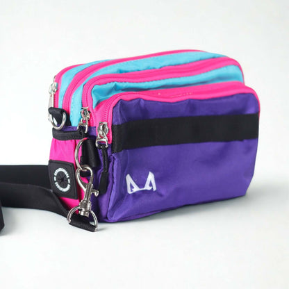 A purple and pink dog training fanny pack with black straps and a logo on the front.
