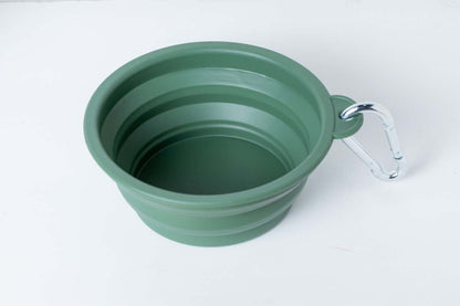 Green collapsible travel bowl with handle on a white background