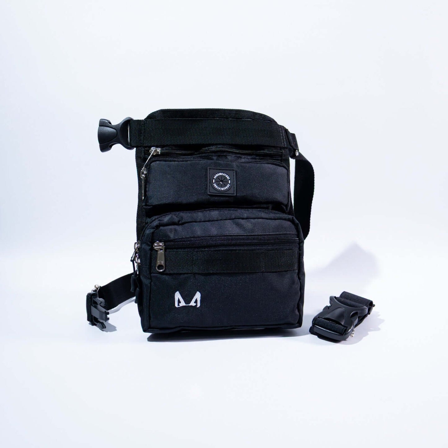 A slim fit thigh treat bag with multiple compartments, including a main pocket, a small front compartment, and a back pocket. It features an adjustable waist strap, a removable elastic thigh strap, and is made from high-quality canvas fabric.