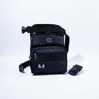 A slim fit thigh treat bag with multiple compartments, including a main pocket, a small front compartment, and a back pocket. It features an adjustable waist strap, a removable elastic thigh strap, and is made from high-quality canvas fabric.