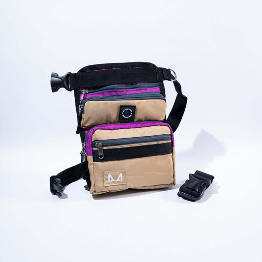 A slim fit thigh treat bag with multiple compartments, including a main pocket, a small front compartment, and a back pocket. It features an adjustable waist strap, a removable elastic thigh strap, and is made from high-quality canvas fabric.
