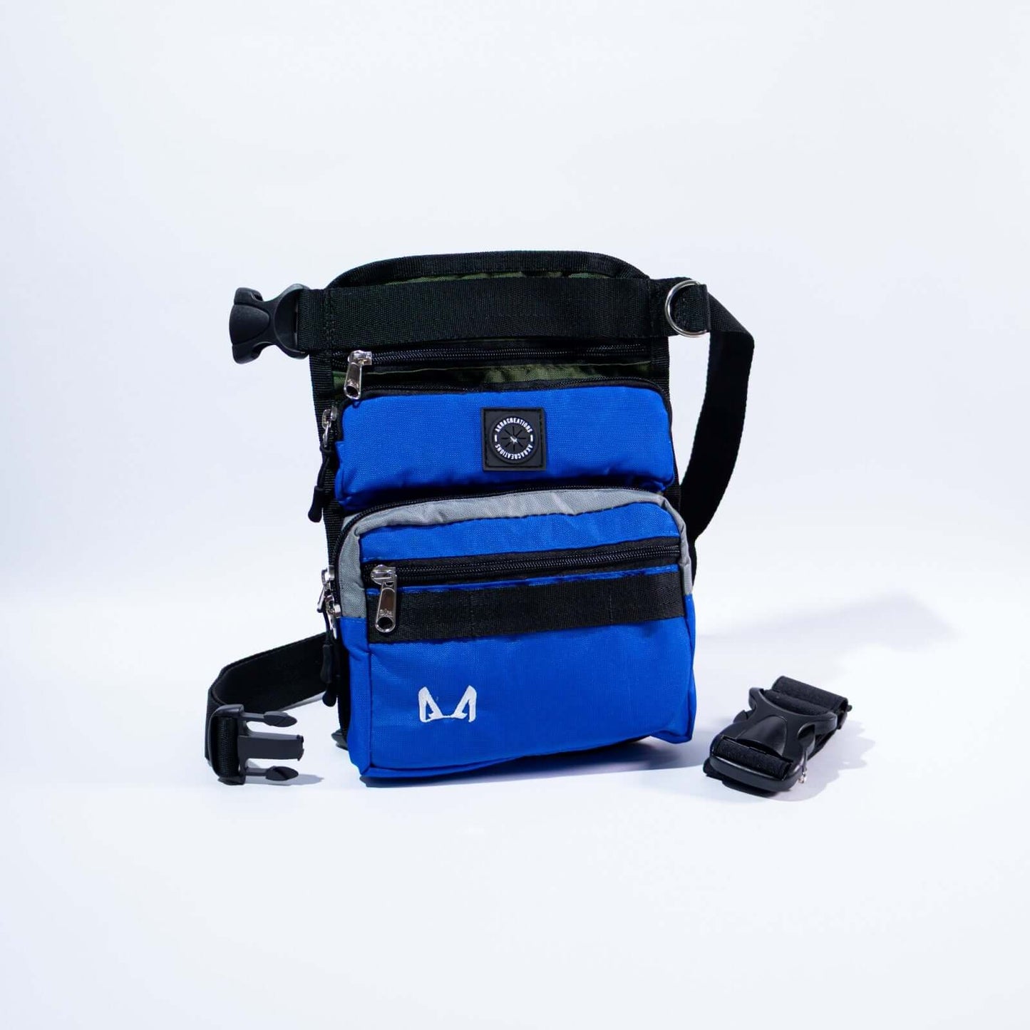 A tactical trio slim fit thigh treat bag with multiple compartments, including a main pocket, a small front compartment, and a back pocket. It features an adjustable waist strap, a removable elastic thigh strap, and is made from high-quality canvas fabric.